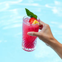Person Holding Drink By Pool